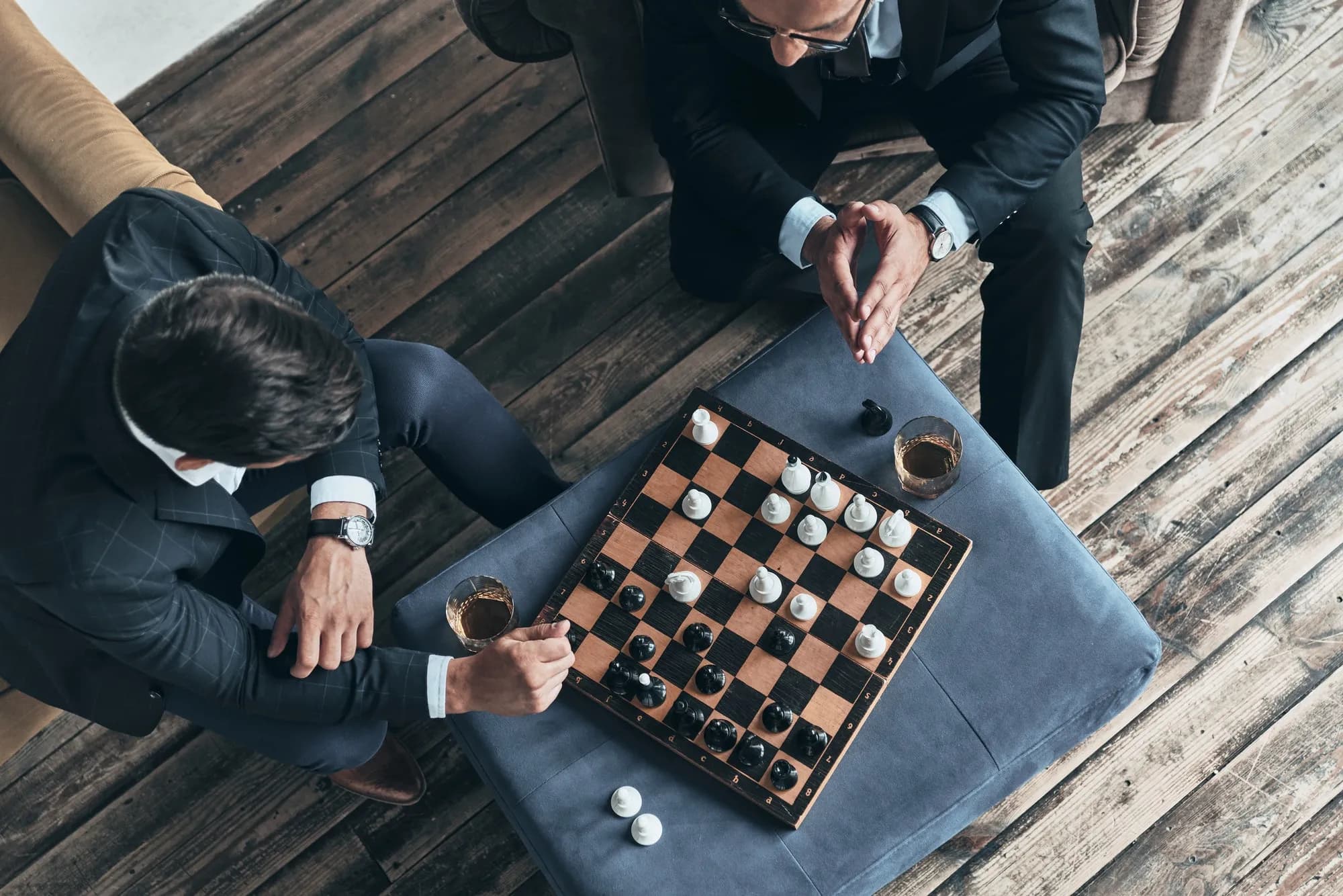 Two players thinking through a position over a chess board